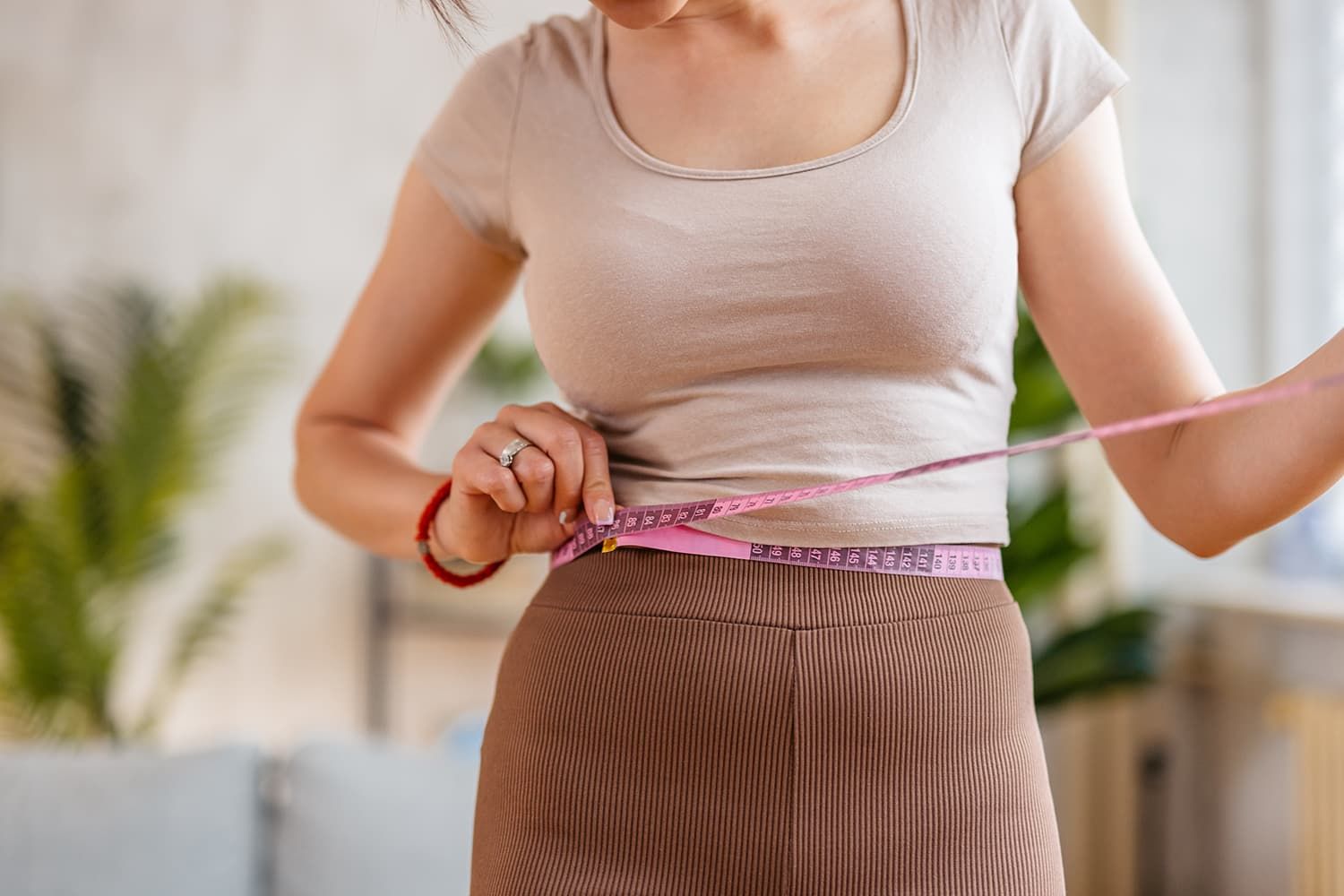 Woman measures waist for healthy weight loss with semaglutide
