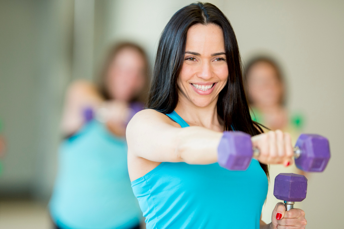 Woman holding dumbbells during group fitness class