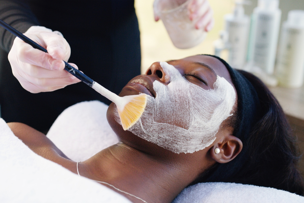 Young African American woman getting a chemical peel at a medical spa